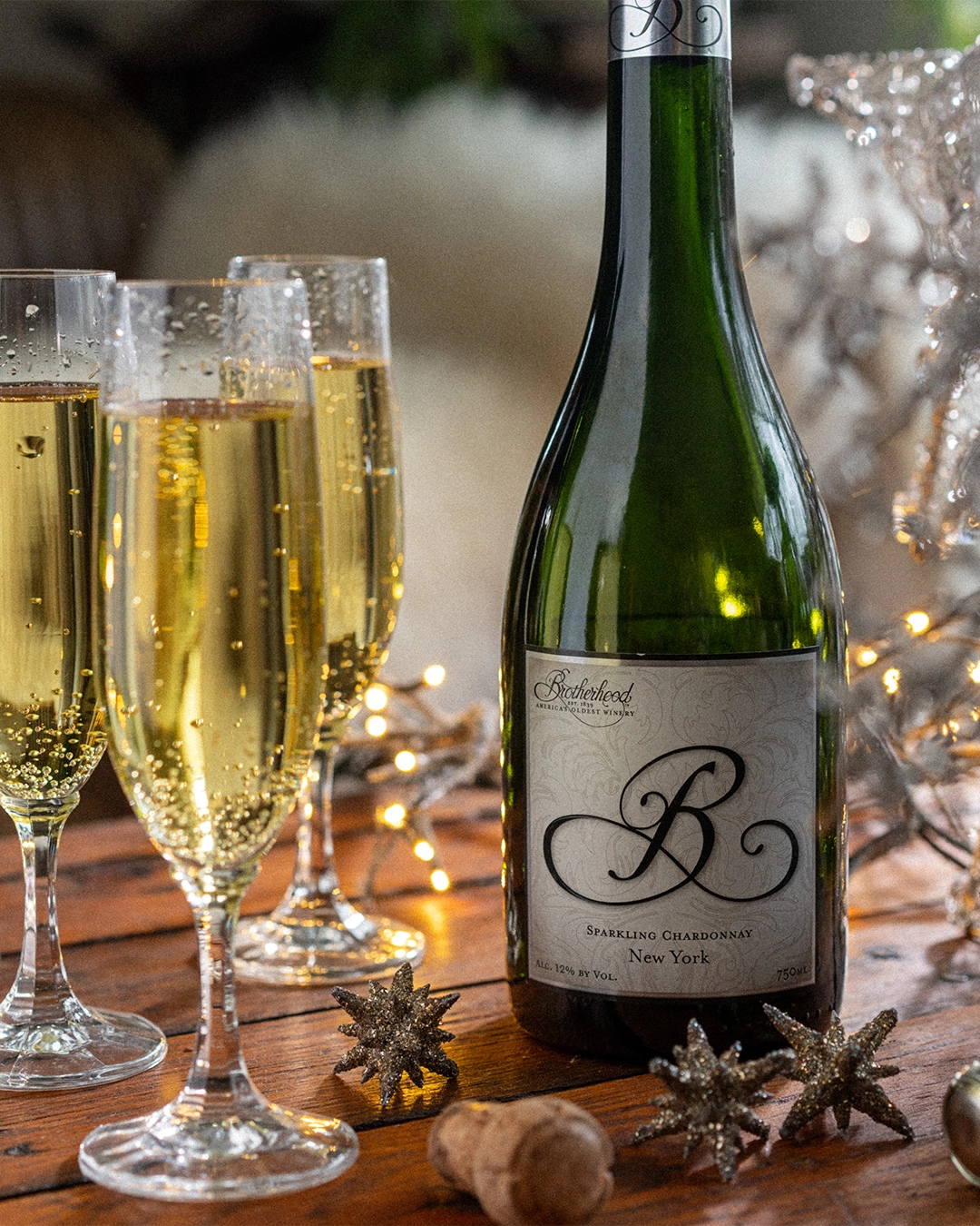 Sparkling wine poured into flutes on a candlelit wooden table
