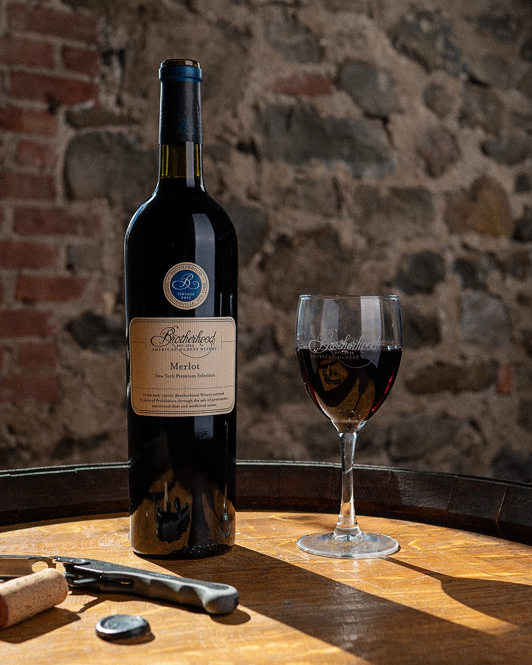Red wine bottle on rustic barrel table inside historic tasting room